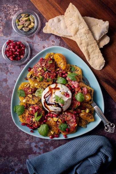 burrata salad with mandarin oranges and pomegranate. - iraanse cultuur stockfoto's en -beelden