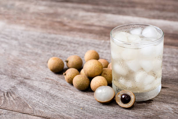 longan juice Glass of fresh longan juice and longan fruit on wooden table background. longan stock pictures, royalty-free photos & images