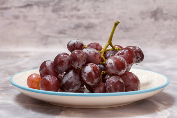 istock Bunch of red grapes on white plate. 1366928935