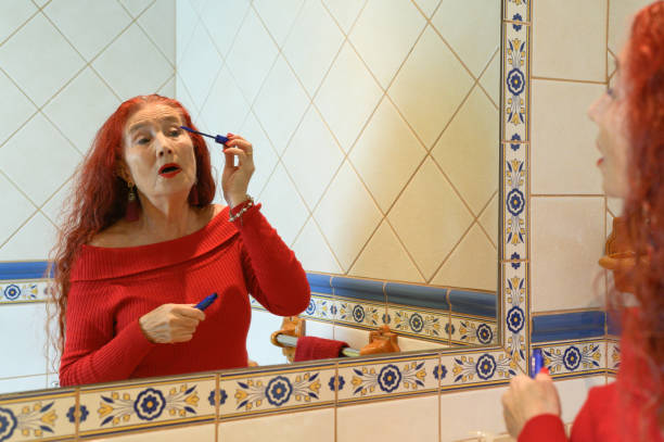 istock Confident elderly woman applying makeup in bathroom 1366930020