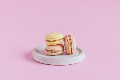 Tasty french macaroons on a pink pastel background.  Place for text.
