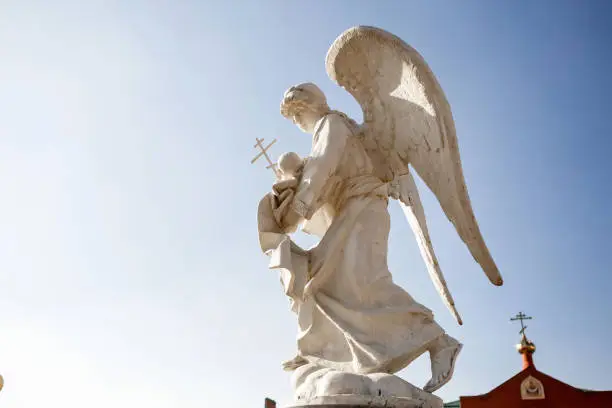 Photo of a statue of the archangel michael against the background of the sky