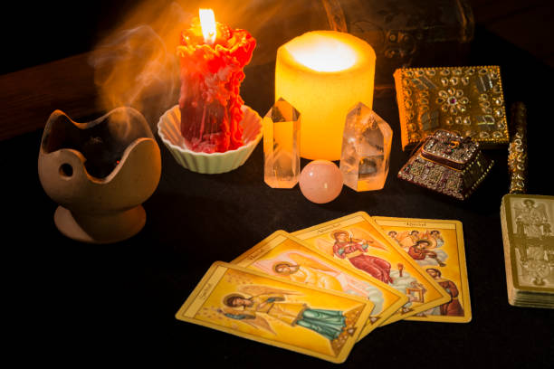 istock Still life with tarot cards, candles, incense and other objects on a black card table. 1366933717