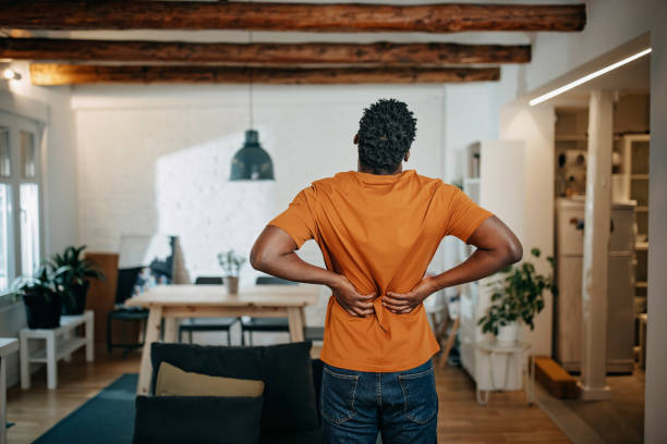 jeune homme afro-américain souffrant de douleur - human spine backache pain back photos et images de collection