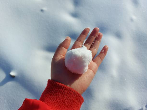 istock Woman holding snow ball with bare hand 1366934882