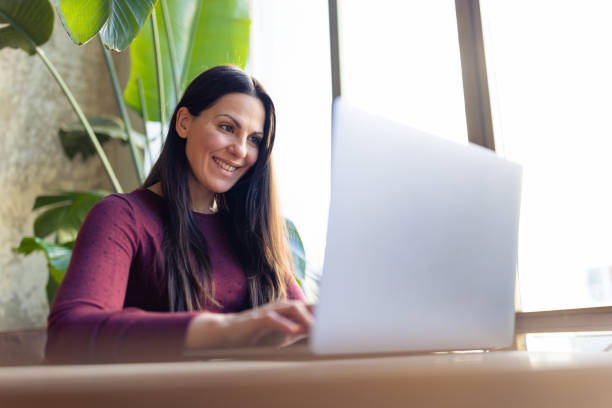 istock Woman using laptop at home 1366937342
