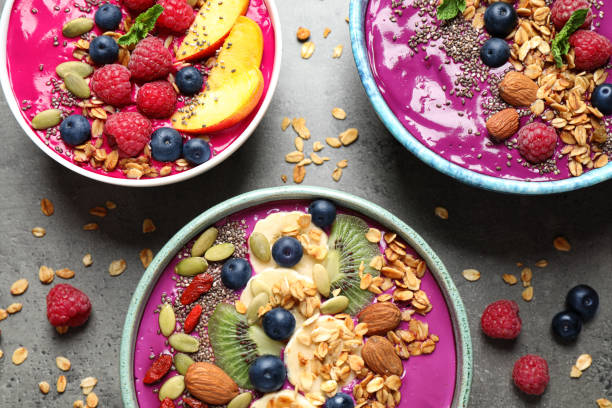istock Delicious acai smoothie with toppings in bowls on table, flat lay 1366938829