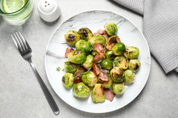 istock Delicious fried Brussels sprouts with bacon served on grey table, flat lay 1366938854