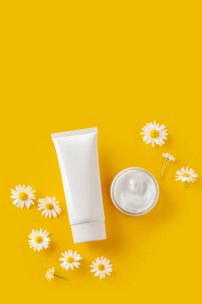 naturalne produkty kosmetyczne z ekstraktem z rumianku na żółtym tle. - chamomile plant daisy spa treatment chamomile zdjęcia i obrazy z banku zdjęć