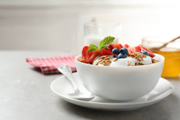 leckeres müsli mit joghurt und beeren zum frühstück auf leichtem tisch serviert - dry strawberry dried food fruit stock-fotos und bilder