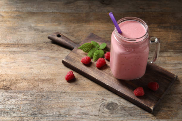istock Yummy raspberry smoothie in mason jar on wooden table. Space for text 1366940225