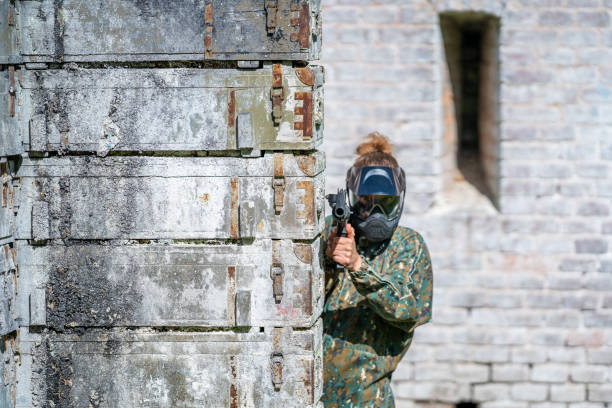istock young woman in action while playing paintball 1366940232