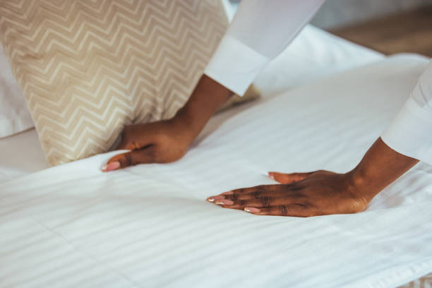istock African maid making bed in hotel room. 1366940553
