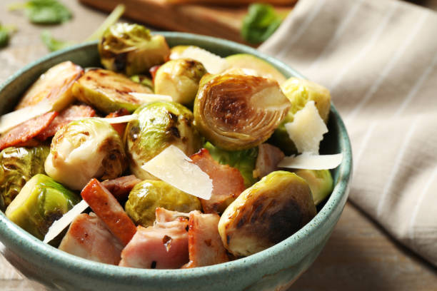 istock Delicious fried Brussels sprouts with bacon in bowl on table, closeup 1366940859
