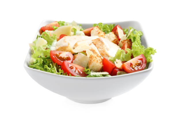 istock Delicious fresh Caesar salad in bowl on white background 1366941734