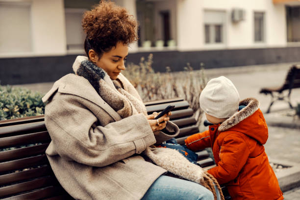 irresponsible babysitter hanging on the phone and doesn't pay attention to the little boy. - careless child rudeness little boys imagens e fotografias de stock