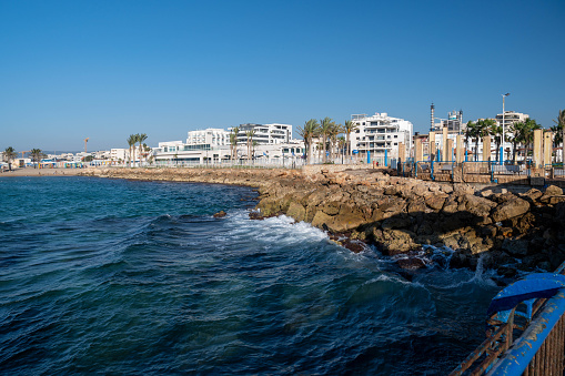 Nahariya's Promenade and Galei Galil Beach view of the sea and the shore from the pier. Sailing boats and kitesurfers in the distance.