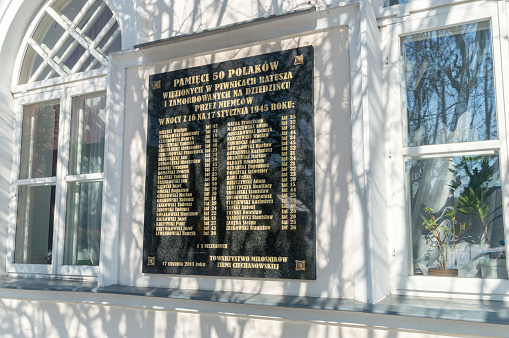 Ciechanow, Poland - October 3, 2021: Memorial plaque with the names of 50 Poles imprisoned and murdered in the town hall yard by the Germans.