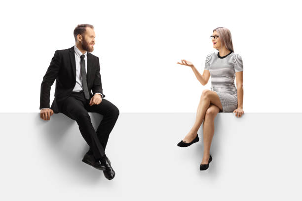 istock Businessman and a casual young woman having a conversation on a blank panel 1366942338