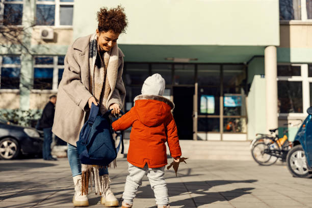 istock A caring babysitter preparing a little boy for the kindergarten while standing in the schoolyard. 1366942597