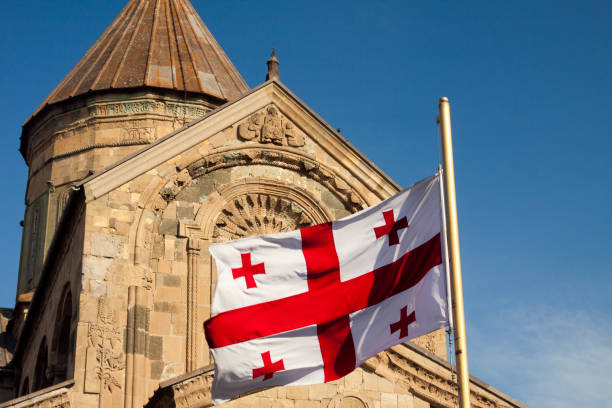 bandera georgiana frente a la catedral de svetitskhoveli. mtskheta, georgia - mtskheta fotografías e imágenes de stock