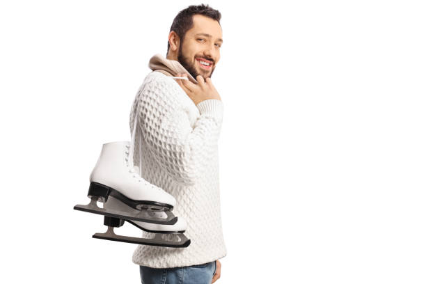 istock Young man carrying ice-skates on his shoulder and smiling 1366943528