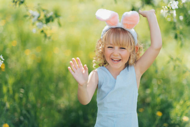 istock Cute funny girl with Easter eggs and bunny ears at garden. easter concept. 1366943683