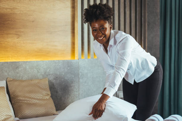 istock Maid making bed in hotel room. 1366947091