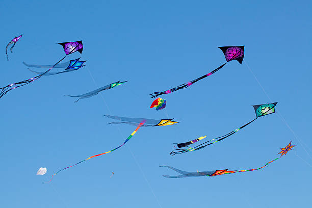 istock Brightly colored kites sailing against clear blue sky 136694713