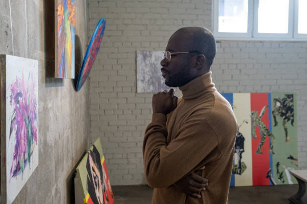 istock Man looking at pictures in gallery 1366948703
