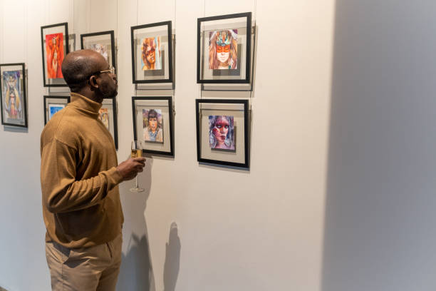 istock Man looking at photos at exhibition 1366948718