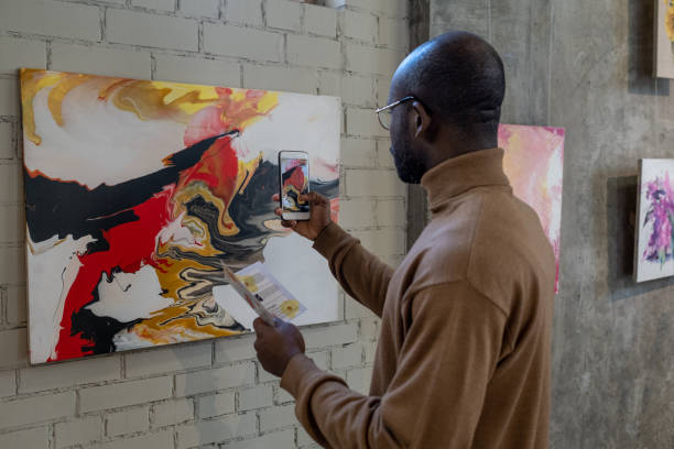 istock Man photographing the artwork in gallery 1366948745