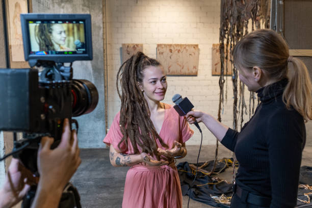 istock Young artist giving an interview at gallery 1366948784