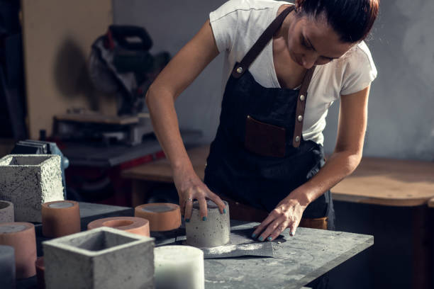 istock Craftswoman in apron working in her workshop making decorative concrete vase. 1366951087