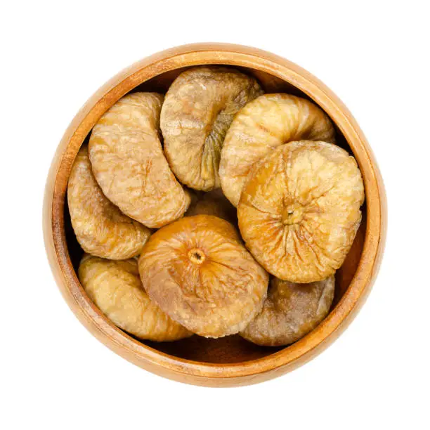 Photo of Sun dried, ripe and whole common figs, Ficus carica, in wooden bowl