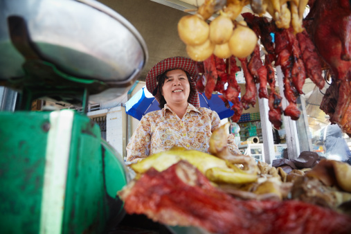 Asian woman selling meat, beef, pork and chicken at street restaurant in Phnom Penh, Cambodia