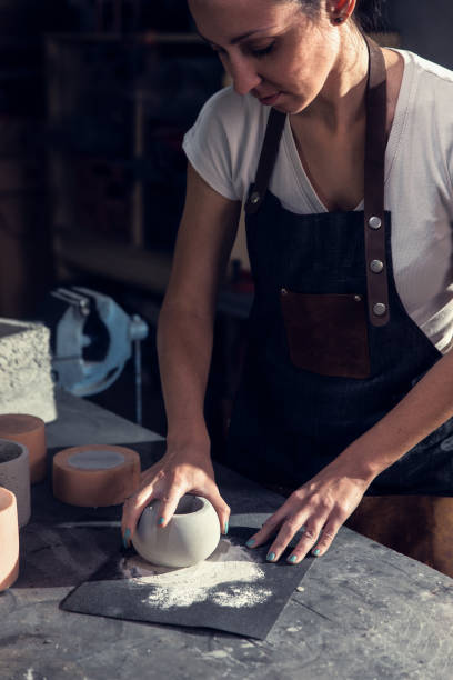 istock Craftswoman in apron working in her workshop making decorative concrete vase. 1366951822