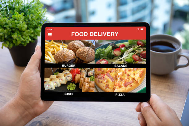 istock male hands holding computer tablet with with app food delivery 1366951899