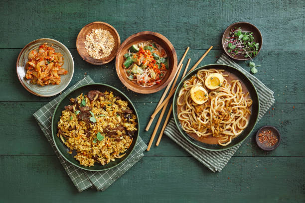 Korean Dishes Dan Dan Noodles (Tantanmen Ramen or Tan Tan Noodles). Korean-style Curry Beef Fried Rice. Flat lay top-down composition on dark green background. japanese food stock pictures, royalty-free photos & images