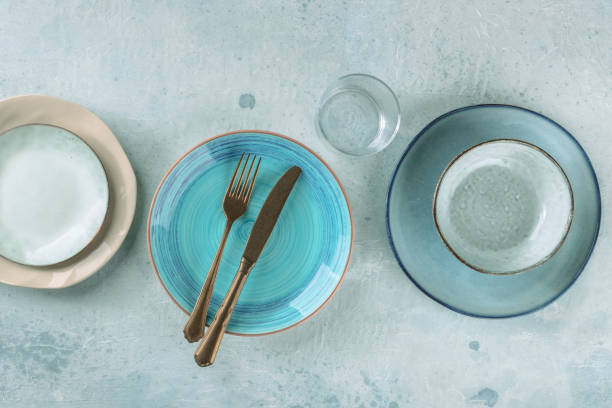 istock Modern dinnerware with cutlery. A vibrant blue plate with a fork and a knife 1366954232