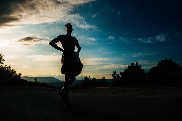 istock Silhouette runner in sunset rise against blue cloudy sky at the mountain 1366957019