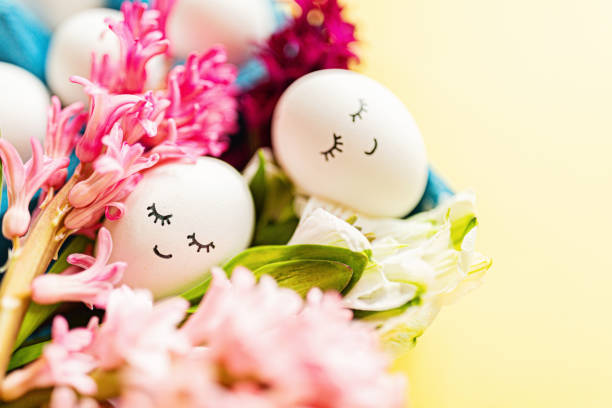 istock Creative easter eggs with cute face and sleepy eyes on pastel yellow background. Happy Easter concept. Flat lay, top view, mockup, template, overhead, copy space 1366958020