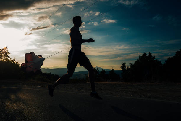 istock Muscular fit sport silhouette model sprinter exercising sprint on forest road 1366958060