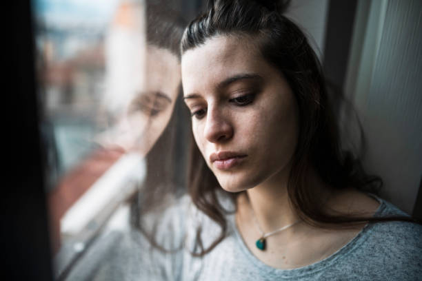 istock Depressed woman by the window. 1366960248
