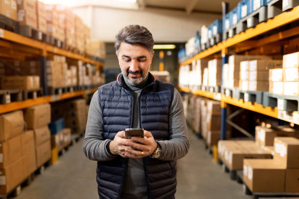 adult foreman in warehouse - family business stockfoto's en -beelden