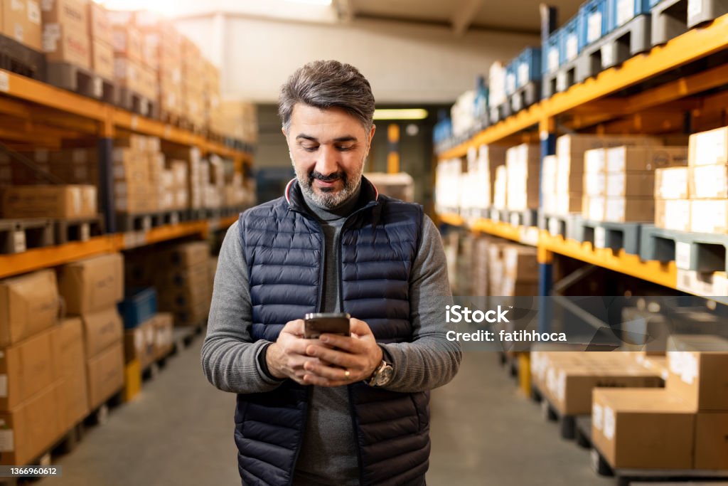Adult Foreman in Warehouse Adult man working in factory warehouse. Small Business Stock Photo