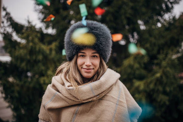 Winter fashion. Portrait positive teen girl in warm clothes. Happy young woman in fur hat doing fun isolated.