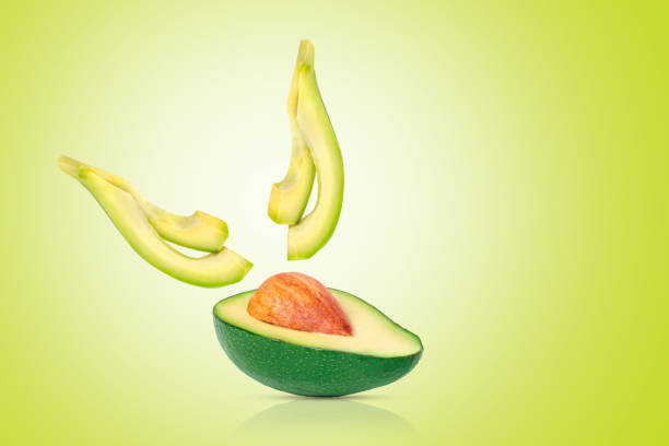 istock Half of an avocado on a bright green background. 1366963476