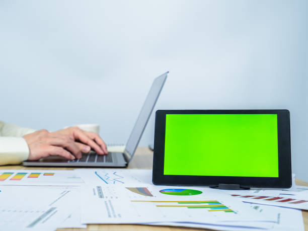 istock green screen on table in front of man working and copy space, 1366965262