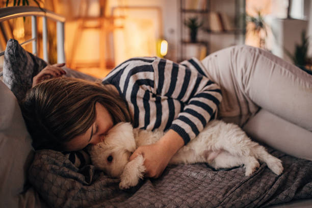 istock Woman sleeping in bed with puppy 1366965628